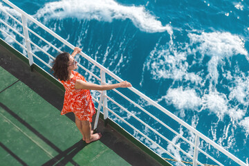 a woman is sailing on a cruise ship and looks at the water