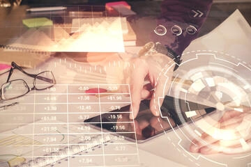 Double exposure of man's hands holding and using a digital device and forex graph drawing. Financial market concept.