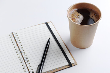 Notebook, pen and glass of coffee