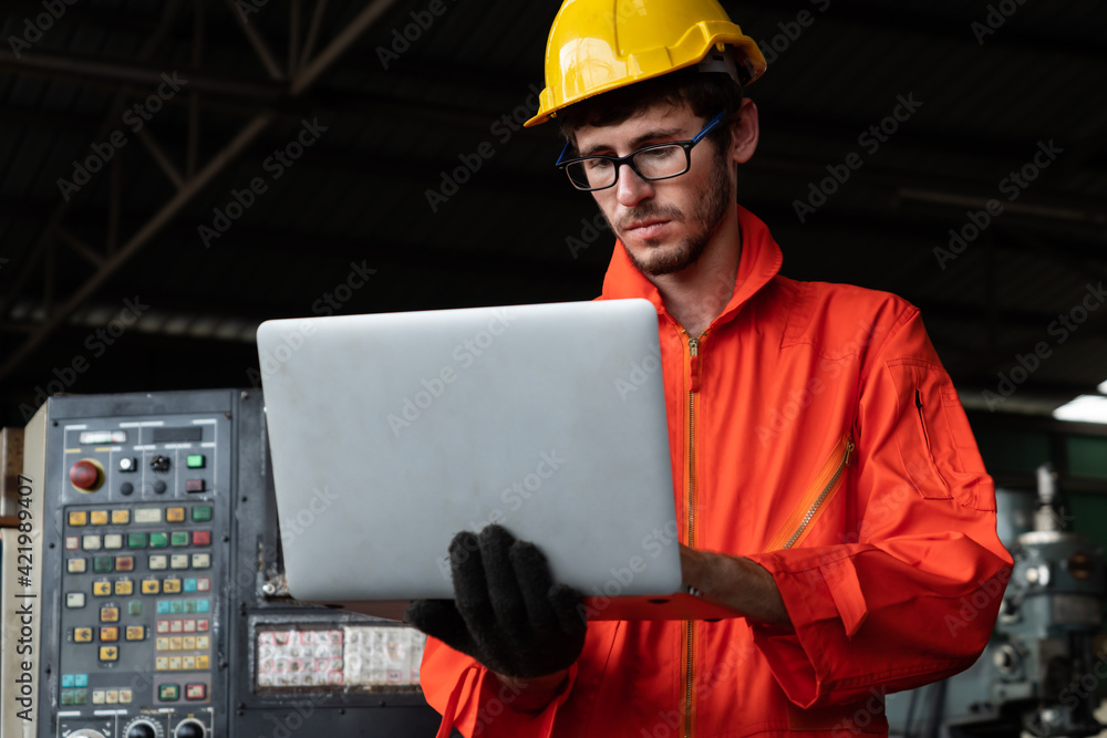 Poster skillful factory worker working with laptop computer to do procedure checklist . factory production 