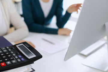Calculator and binders with papers are waiting to be processed by business woman or bookkeeper...