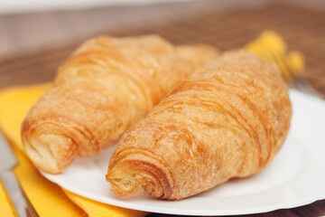 croissants saucer on the table fork with a knife fresh pastries dessert morning