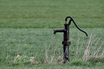 Fototapeta na wymiar Old fashioned hand water pump in a field close to Oss, Netherlands