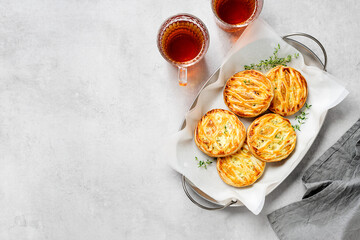 Spinach and ricotta stuffed puff pastry mini pies. Light gray background. top view. space for text