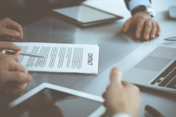 Business people discussing contract working together at meeting in modern office. Unknown businessman and woman with colleagues or lawyers at negotiation