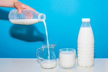 milk on a white table on a blue background. Useful drink.