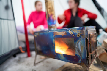 Life in a lavvo tent or tipi in the cold winter. Focus on the hot firestove that heats up the tent....