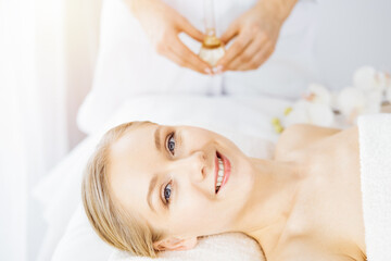 Obraz na płótnie Canvas Happy beautiful woman smiles before spa procedures. Beauty and joy concept