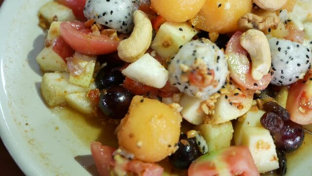 Close Up Footage of Thai Style Mix Exotic Fruits Somtum (Salad) with Sweet and Salty Dressing Included Dragon Fruit, Cashew Nut, Grape, Guava, Melon and Tomato