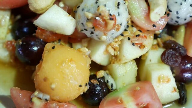 Close Up Footage of Thai Style Mix Exotic Fruits Somtum (Salad) with Sweet and Salty Dressing Included Dragon Fruit, Cashew Nut, Grape, Guava, Melon and Tomato