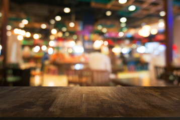Empty dark wooden table in front of abstract blurred bokeh background of restaurant . can be used for display or montage your products.Mock up for space