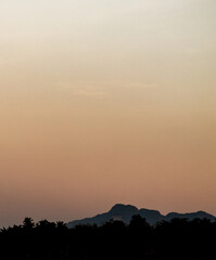 Sunset with sand suspended in the atmosphere, coluring the sky red, over some trees silhouettes