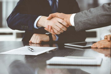 Obraz premium Handshake as successful negotiation ending, close-up. Unknown business people shaking hands after contract signing in modern office