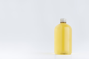 Transparent plastic low thick bottle with orange drink, cooking oil or cosmetic produce with silver cap mockup on white background, template, copy space.