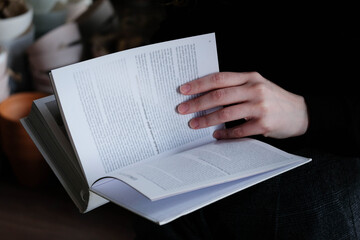 Woman reading a book, girl holds white book while reading at home. Reading mock up , close up details. 