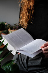 Woman reading a book, girl holds white book while reading at home. Reading mock up , close up details. 