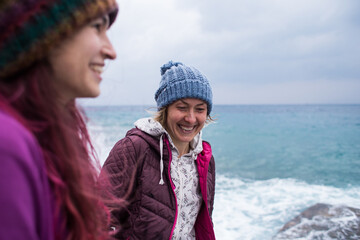 Fototapeta na wymiar two girls laugh on the beach while walking