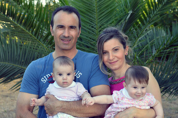 Ritratto di famiglia con mamma, papa e due gemelline.