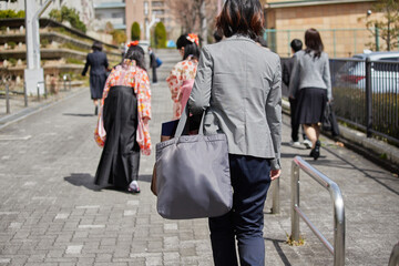 春の小学生の卒業式後家に帰る親子の姿