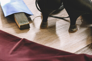 Wooden shoe brush next to ballroom dance shoes and workout clothes. Use a brush to loosen the sole...