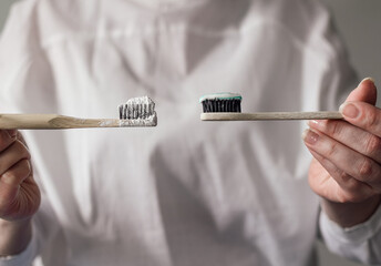 A woman holds toothbrushes in her hands. Choice of tooth powder or paste. Eco-friendly. No waste