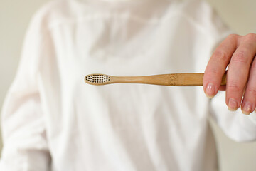 A woman shows how to properly dispose of a bamboo toothbrush, tears off the shield with pliers. Eco activist. No waste. Waste recycling. Step by step 2