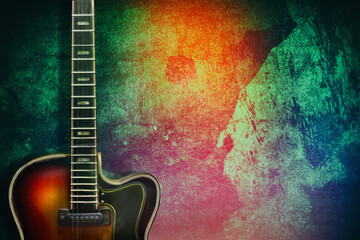 Old, jazz electric guitar on a multicolored grunge background. Copy space. Background for music...