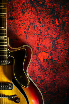 Old, jazz electric guitar on a red grunge background. Copy space. Background for music festivals, concerts. Musical education. Concert concept.