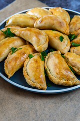 Empanadas. Traditional Latin American baked beef pastry on a plate with parsley garnish. Gluten free savory appetizer with meat stuffing or filling. Handmade typical dish in Spain or Argentina.