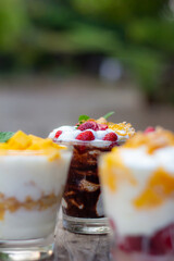 greek yogurt homemade with mango strawberries chocolate Olive leaf on wooden table