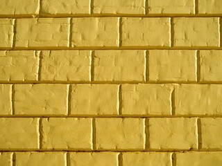 Background of a yellow wall of a city building. The texture of brickwork made of small bricks and large blocks. The concept of the facade of the house for computer modeling.