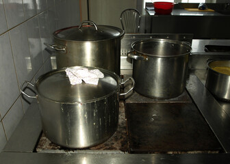 metal pots, pots and pans on the stove in the kitchen