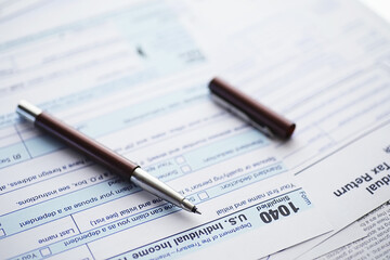 Naklejka na ściany i meble Annual tax reporting. Tax form on the table. Financial statements for signature.