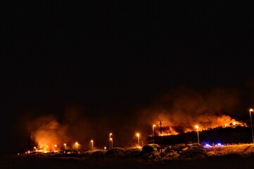 Fototapeta na wymiar forest fire at night next to highway and police blocking traffic