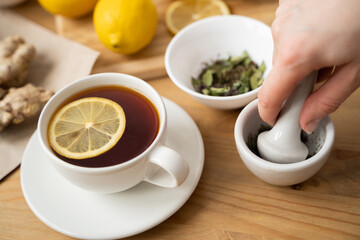 Cup of ginger tea with honey and lemon on wooden table