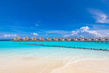 Fototapeta premium Ocean lagoon bay view, blue sky and clouds with wooden jetty and over water bungalows, villas, endless horizon. Meditation relaxation tropical background, sea ocean water. Skyscape seascape background