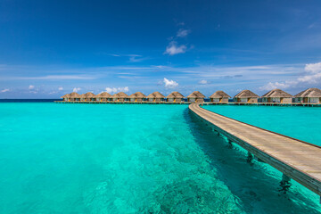 Fototapeta na wymiar Ocean lagoon bay view, blue sky and clouds with wooden jetty and over water bungalows, villas, endless horizon. Meditation relaxation tropical background, sea ocean water. Skyscape seascape background