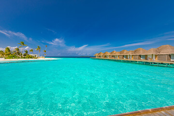 Ocean lagoon bay view, blue sky and clouds with wooden jetty and over water bungalows, villas, endless horizon. Meditation relaxation tropical background, sea ocean water. Skyscape seascape background