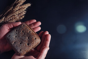 Fresh loaves of bread with wheat and gluten on a black table. Bakery and grocery concept. Fresh, healthy sorts of rye and white loaves food closeup. Fresh homemade bread with cereals.