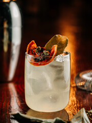 white alcoholic cocktail with ice cubes on wooden bar counter