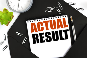 ACTUAL RESULT. text on a sheet of notepad on a black envelope on a light background