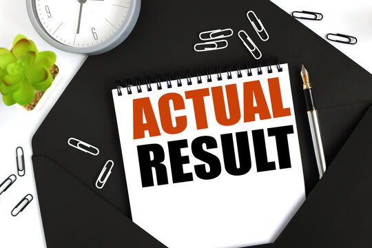ACTUAL RESULT. text on a sheet of notepad on a black envelope on a light background