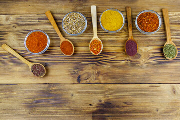 Set of different aromatic spices on wooden table. Top view, copy space