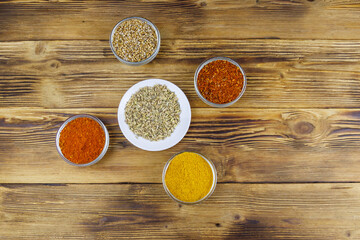 Set of different aromatic spices on wooden table. Top view