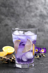 Organic blue Anchan with lemon in glass on grey table. Herbal tea