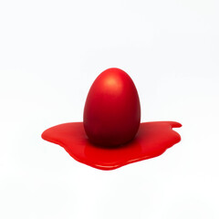 Red egg melting on white background. Creative Easter concept.