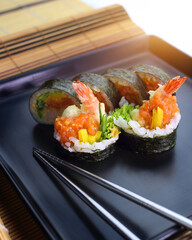 tasty and colorful sushi rolls served on a black plate