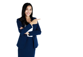 Portrait studio shot of a young friendly face and beautiful Asian woman in dark blue office business suit standing with friendly smile face and pose to camera and pointing finger to blank space