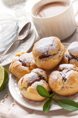 Homemade profiteroles with chocolate cream and powdered sugar