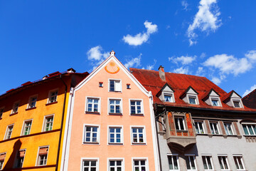 Colorful tenement houses with attics . Facade with Sundial . European residential district 